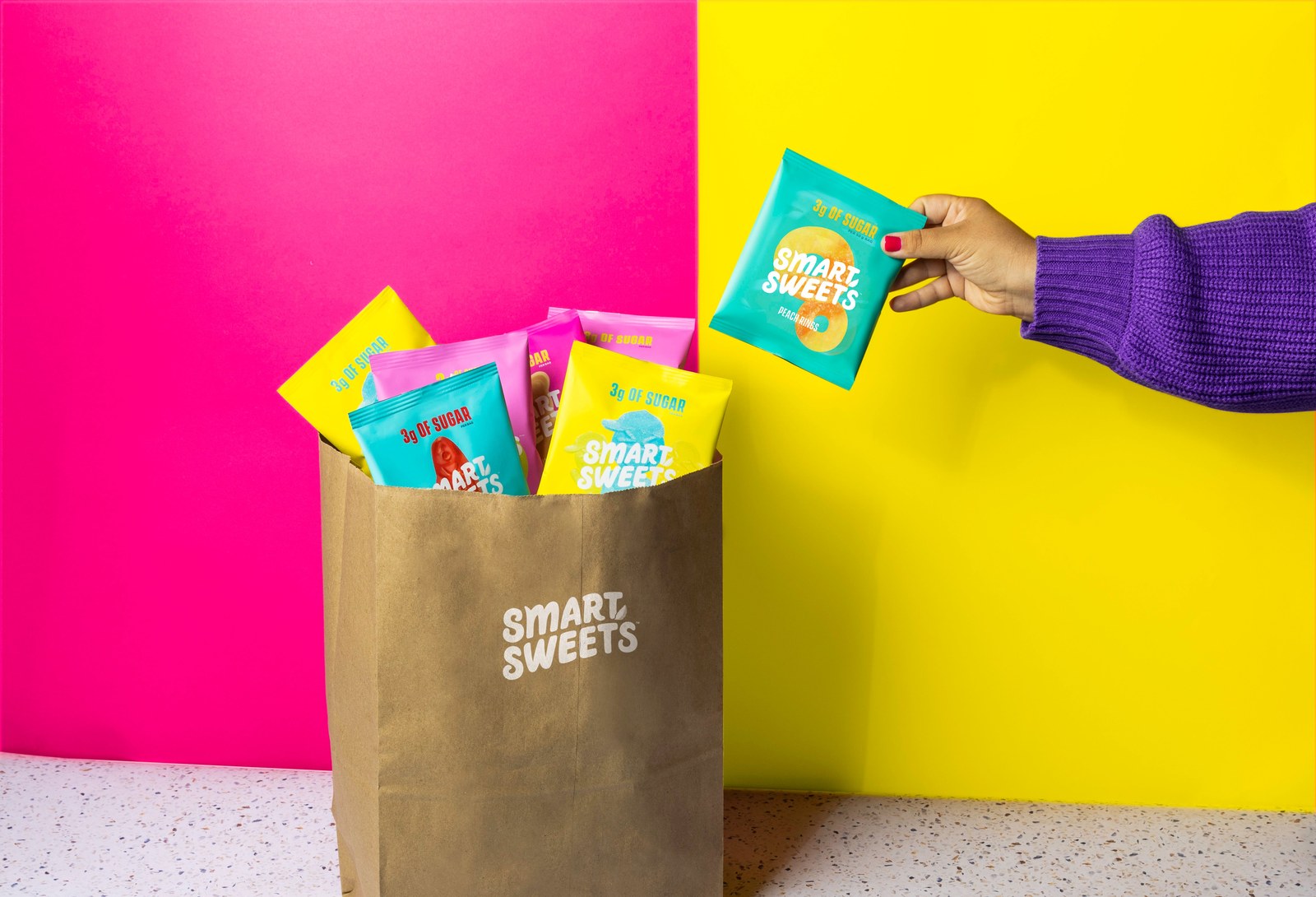 Hand placing SmartSweets bags into a shopping bag
